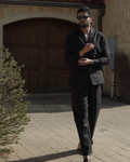 Sher Valor Obsidian Set – men's black linen shirt and trousers, full body walking shot against Mediterranean stone architecture