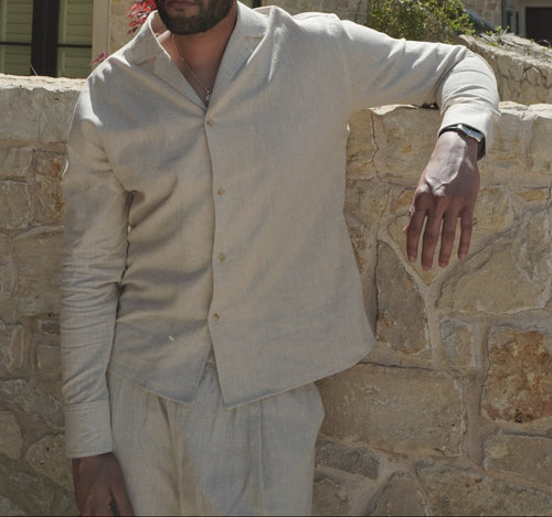 Sher Valor Sandstone Set – men's beige linen shirt close-up, relaxed open collar and button detail against stone wall